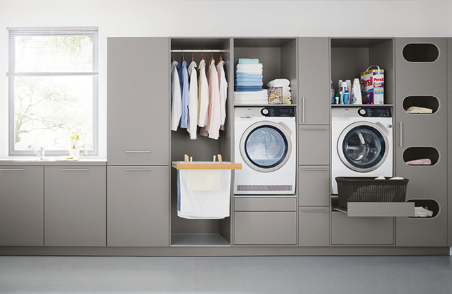 graue Küchenfronten inklusive zweier Waschmaschinen und eingeräumter Kleider