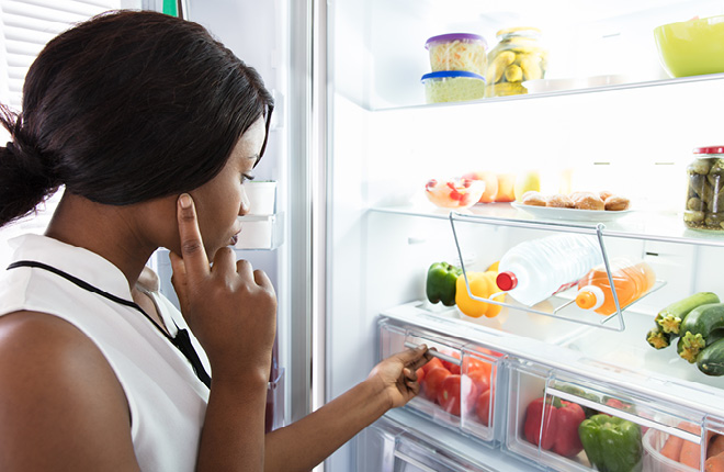 Frau vor geöffnetem Kühlschrank