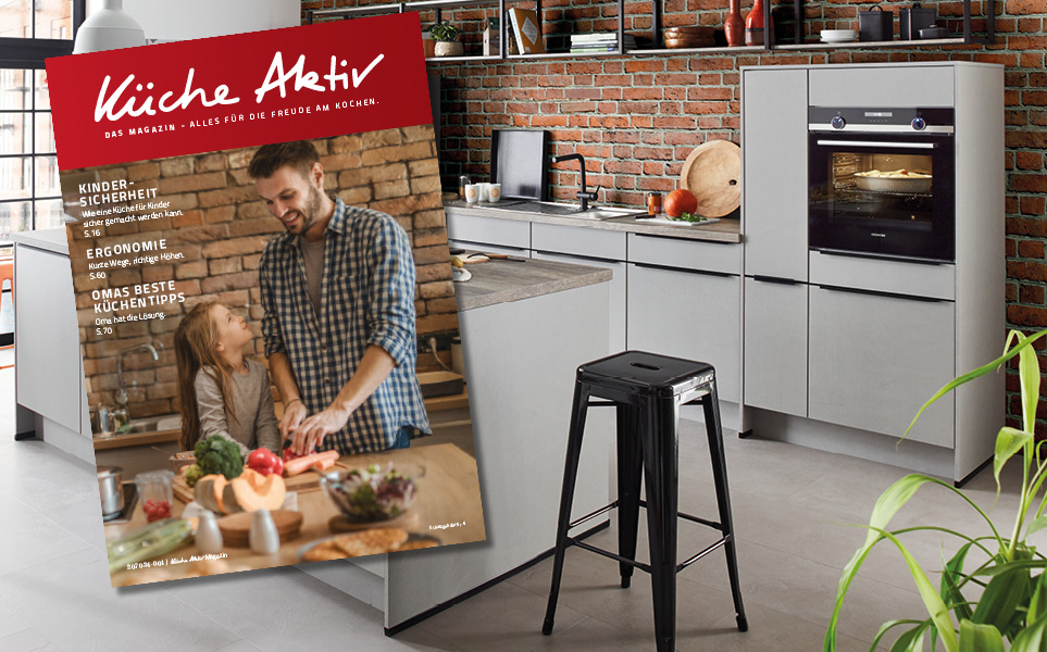 Katalog mit Vater und Tochter in der Küche über Küchenübersicht gelegt